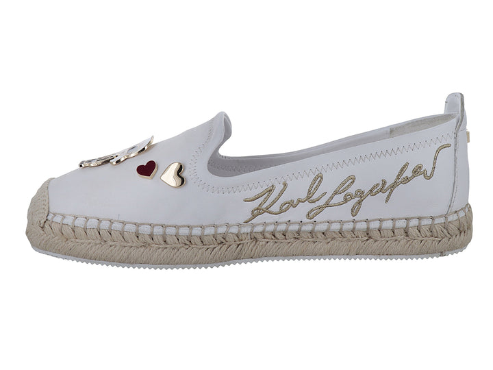 Zapato blanco tipo alpargata con suela de yute y detalles metálicos decorativos.