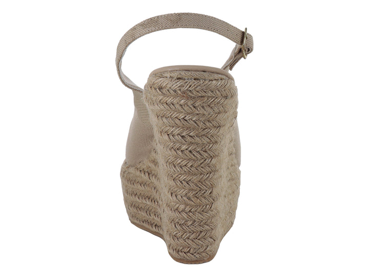 Sandalia de mujer color capuchino con plataforma de cuña en fibras naturales y correa ajustable al tobillo.