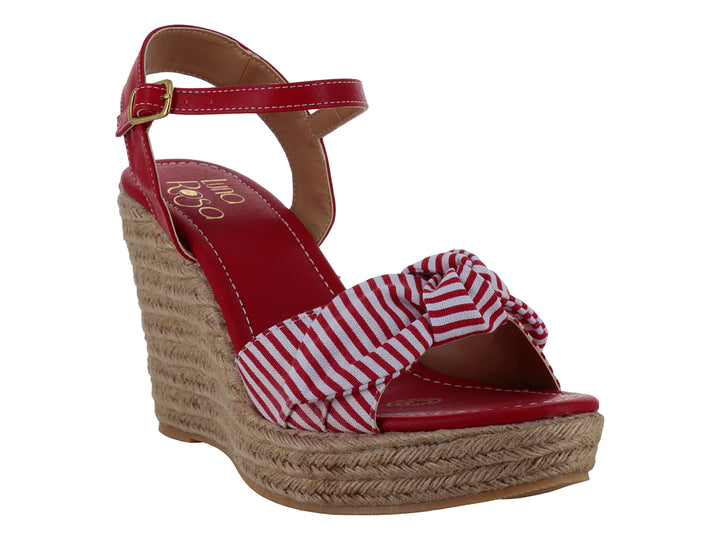 Sandalia roja de plataforma cuña con moño a rayas blancas y rojas y base de yute.