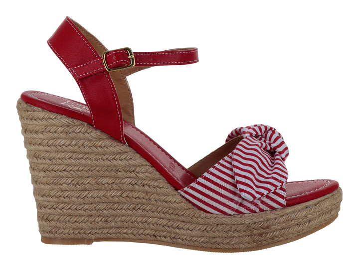 Sandalia roja de plataforma cuña con moño a rayas blancas y rojas y base de yute.