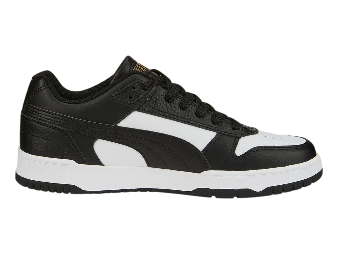 Tenis PUMA RBD Game Low en colores negro y blanco con detalles dorados, diseño deportivo de corte bajo.