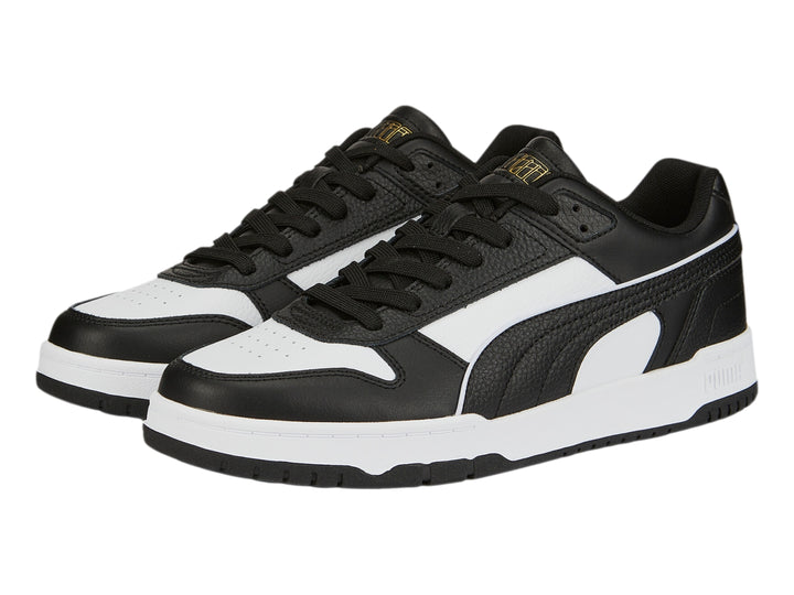 Tenis PUMA RBD Game Low en colores negro y blanco con detalles dorados, diseño deportivo de corte bajo.