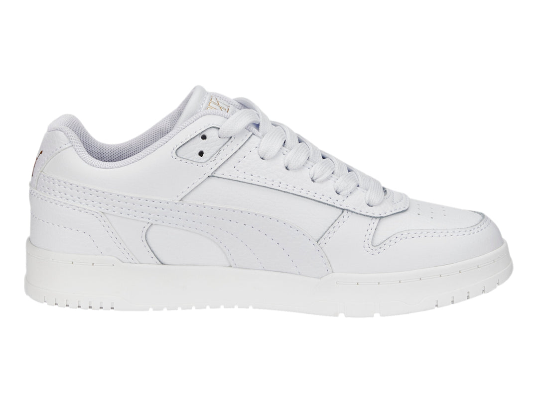 Tenis PUMA RBD Game Low JR en color blanco con detalles dorados, diseño deportivo de corte bajo para niños.