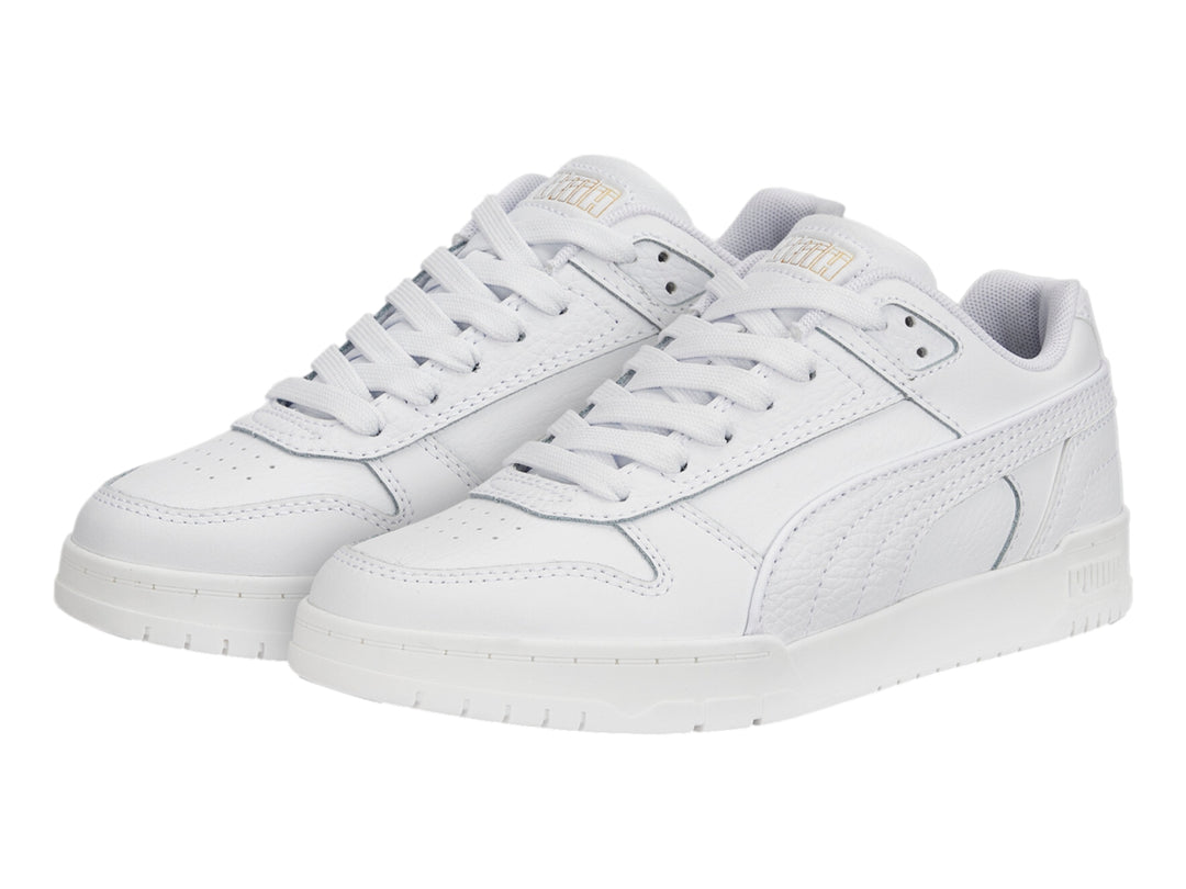 Tenis PUMA RBD Game Low JR en color blanco con detalles dorados, diseño deportivo de corte bajo para niños.
