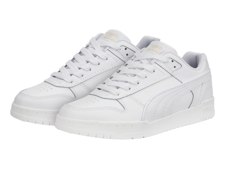 Tenis PUMA RBD Game Low JR en color blanco con detalles dorados, diseño deportivo de corte bajo para niños.