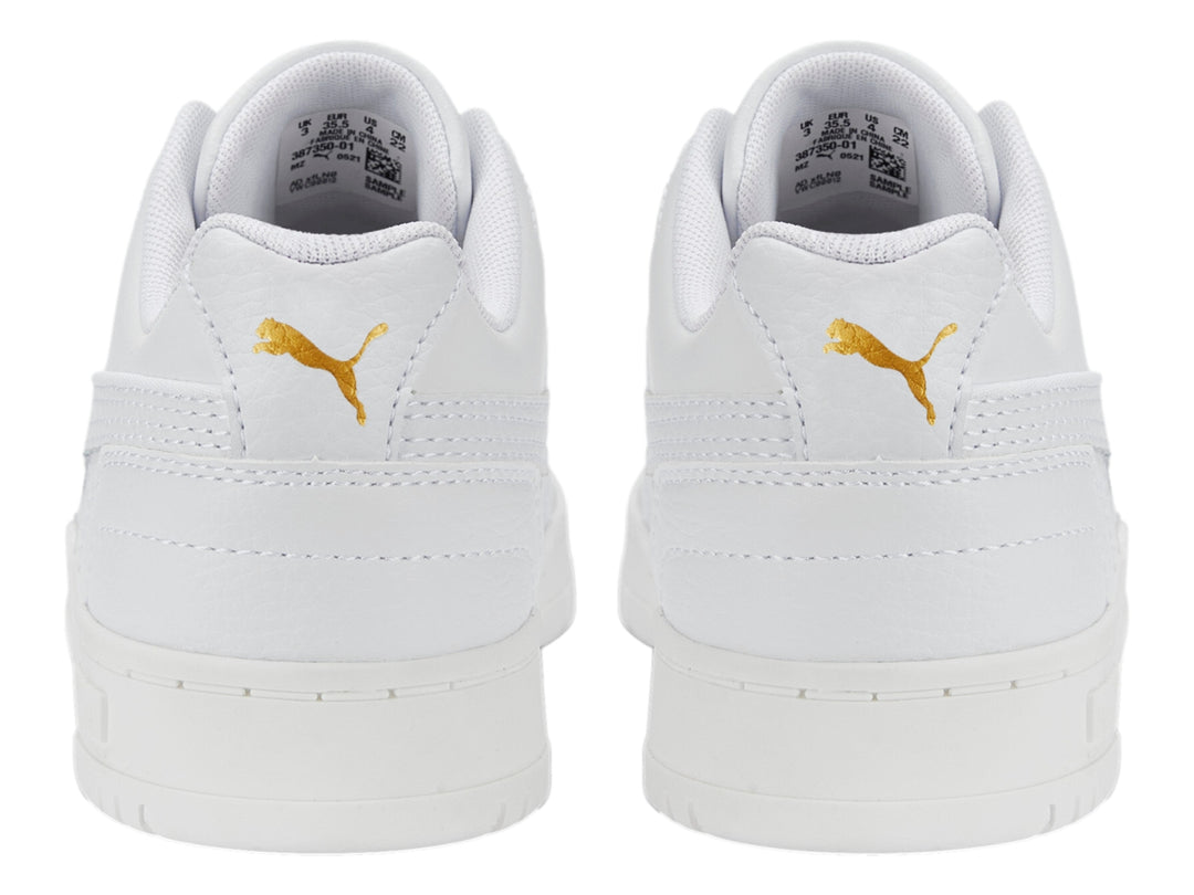 Tenis PUMA RBD Game Low JR en color blanco con detalles dorados, diseño deportivo de corte bajo para niños.