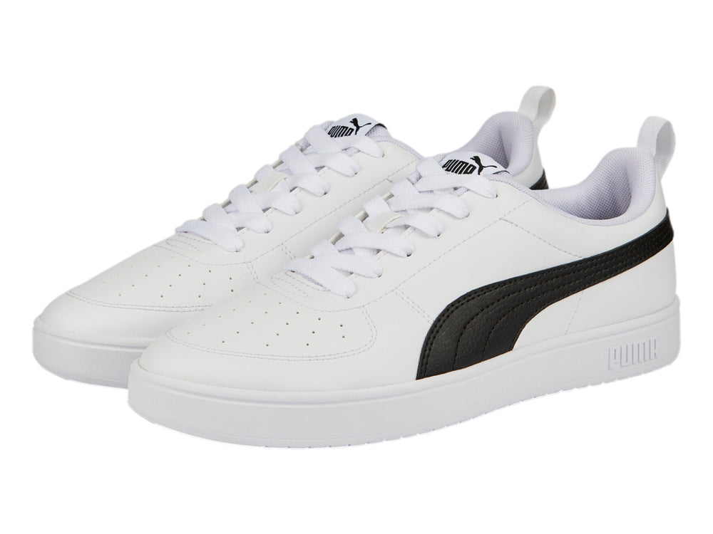 Tenis PUMA Rickie color blanco con franja negra lateral y suela blanca.