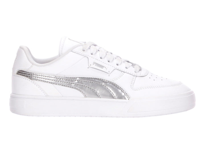 Tenis PUMA blancos con franja lateral plateada metálica y suela blanca.