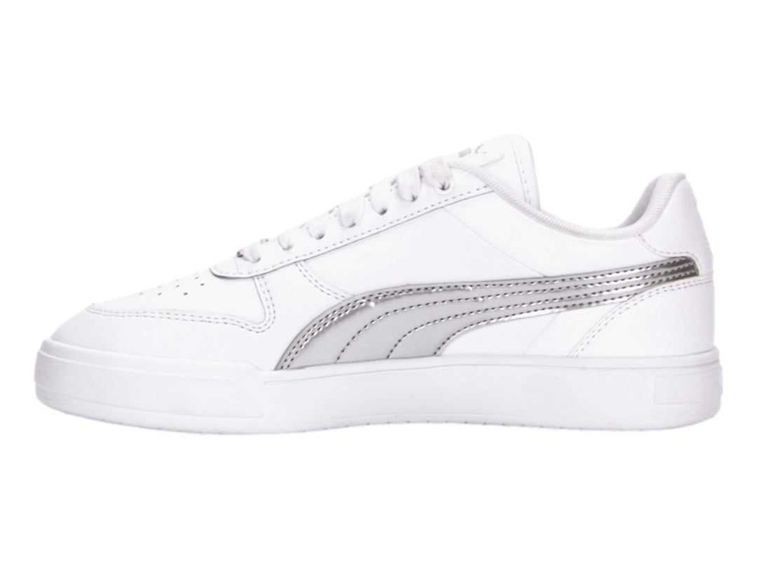 Tenis PUMA blancos con franja lateral plateada metálica y suela blanca.