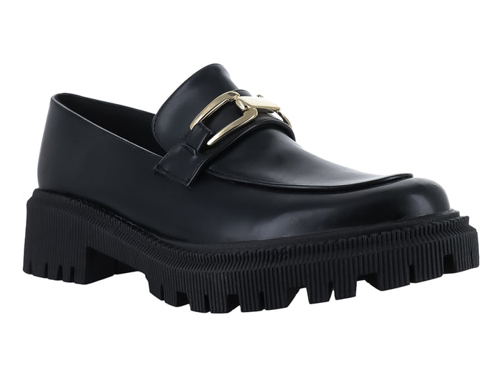 Zapato mocasín negro de cuero con hebilla dorada y suela de plataforma gruesa dentada.