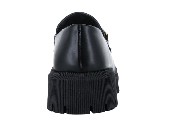Zapato mocasín negro de cuero con hebilla dorada y suela de plataforma gruesa dentada.