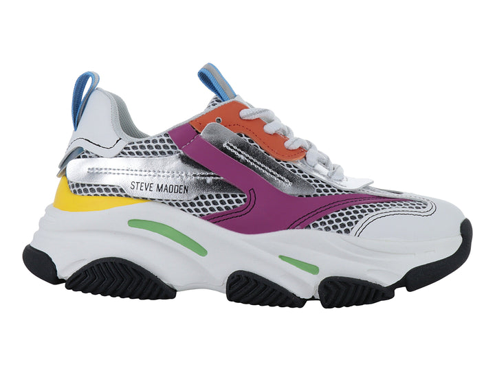 Tenis deportivos infantiles blancos con detalles multicolores y suela robusta negra.