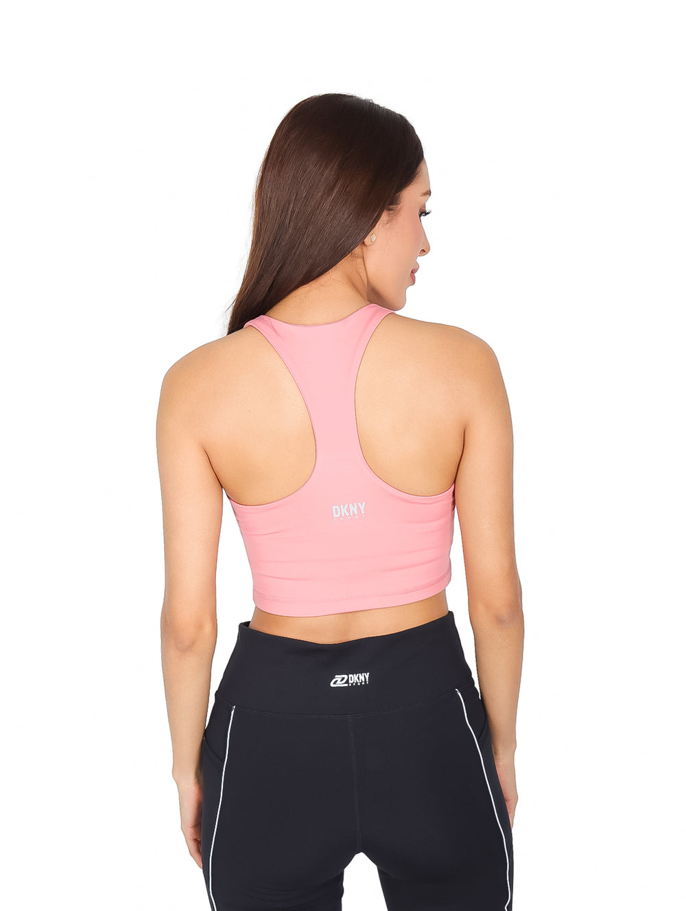 Mujer vistiendo un crop top deportivo color rosa con cuello en V y espalda racerback.