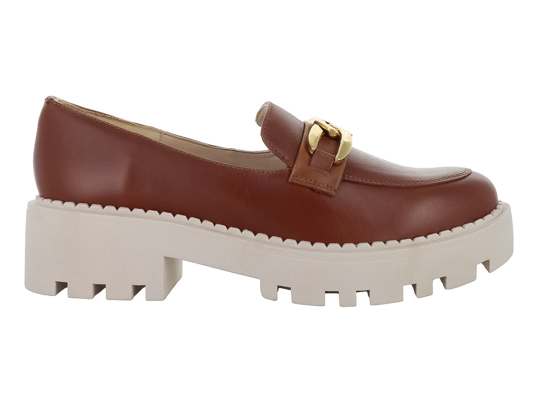 Zapato mocasín de piel color miel con hebilla dorada y suela blanca ancha tipo plataforma.