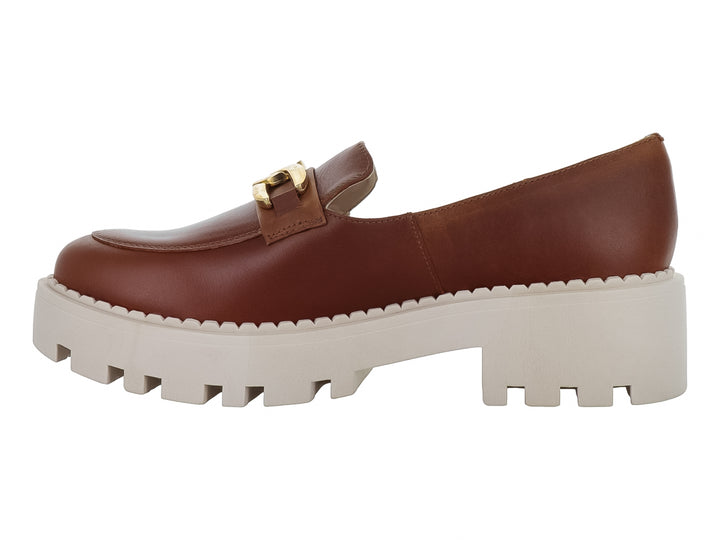 Zapato mocasín de piel color miel con hebilla dorada y suela blanca ancha tipo plataforma.