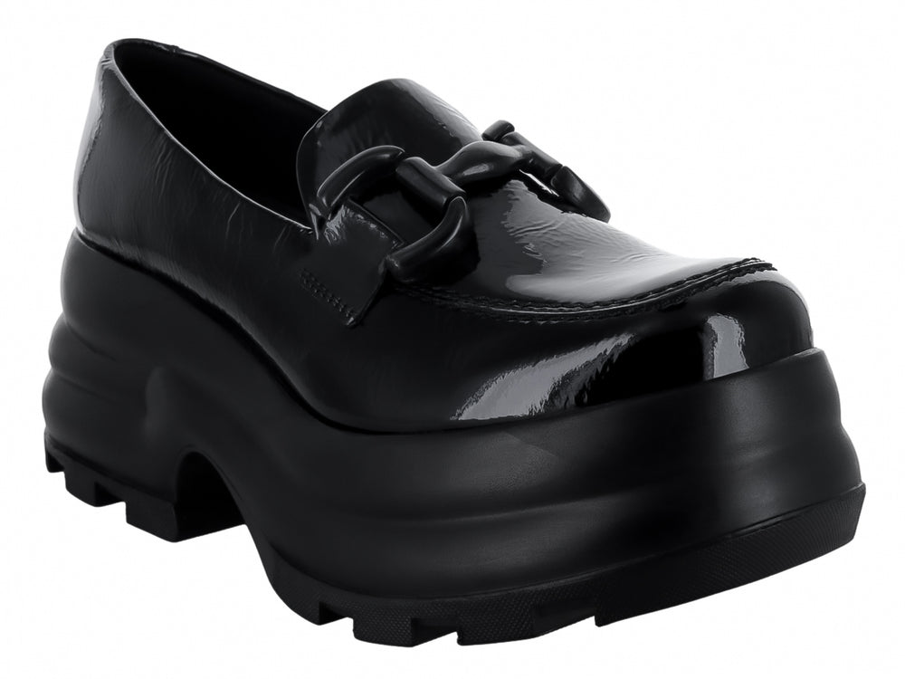 Zapato mocasín negro de piel brillante con plataforma gruesa y hebilla decorativa.