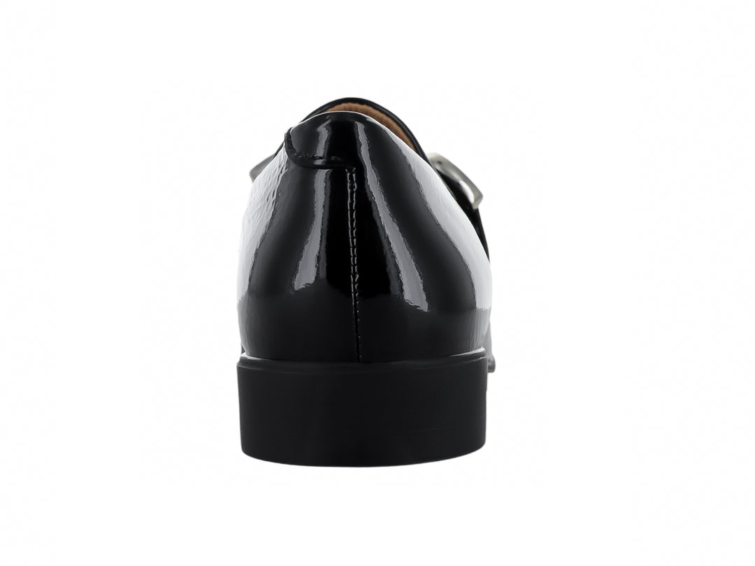 Zapato mocasín de piel negra brillante con hebilla metálica plateada.