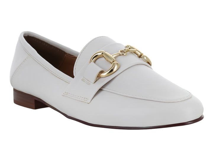 Zapato tipo mocasín color latte para mujer con herraje metálico dorado en la parte superior.