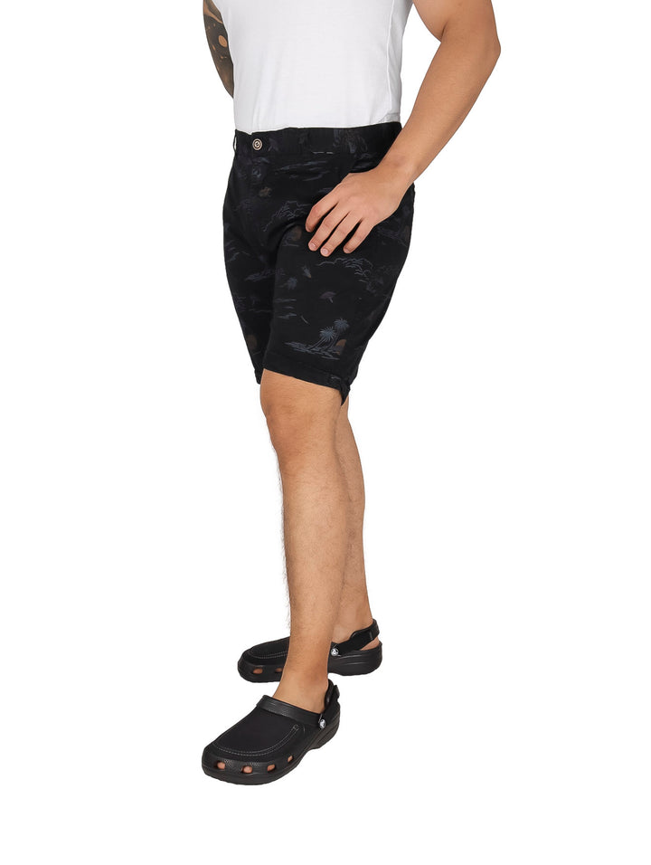 Hombre usando bermudas negras de gabardina con estampado sutil y calzado negro.