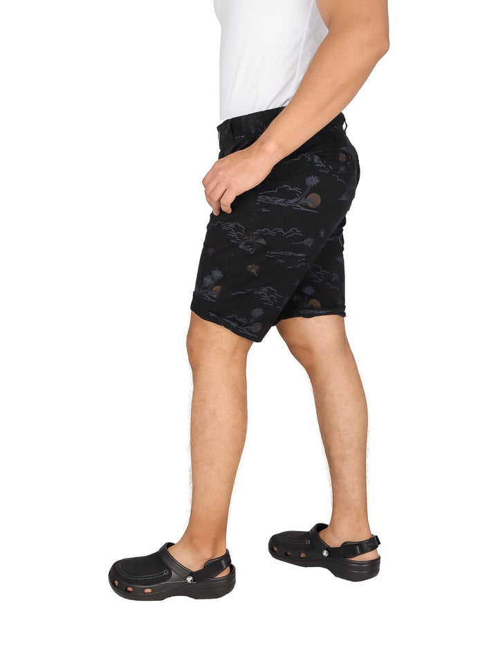 Hombre usando bermudas negras de gabardina con estampado sutil y calzado negro.