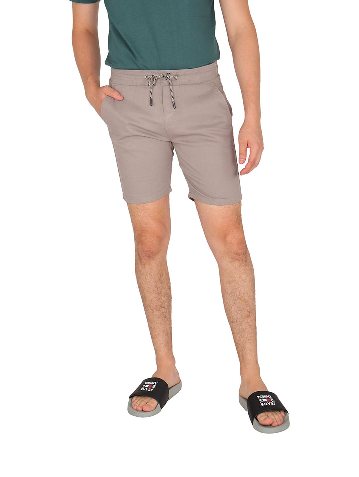 Hombre vistiendo bermudas de gabardina color gris con cordón ajustable.