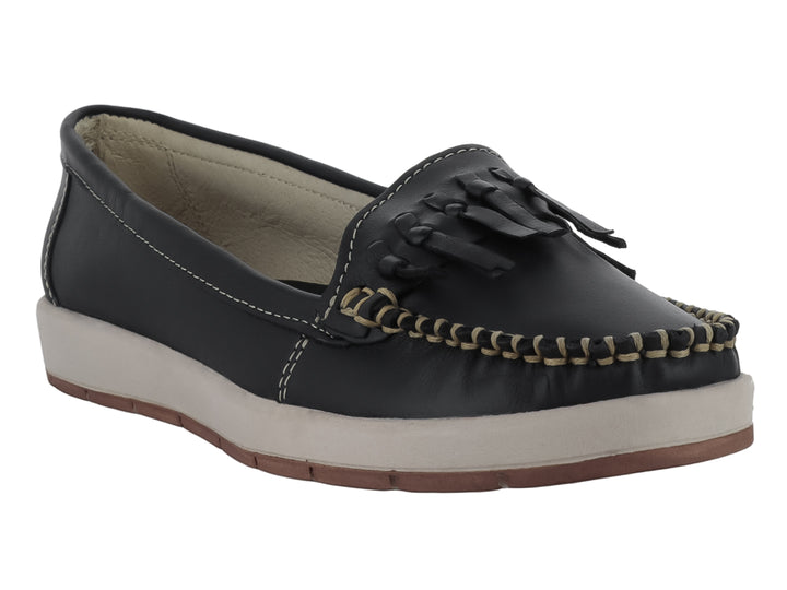 Zapato tipo mocasín color negro con borlas decorativas y suela beige contrastante.