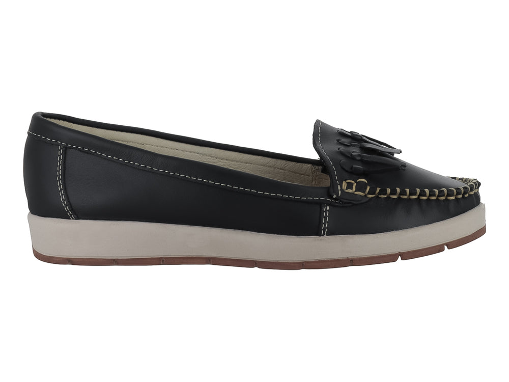 Zapato tipo mocasín color negro con borlas decorativas y suela beige contrastante.