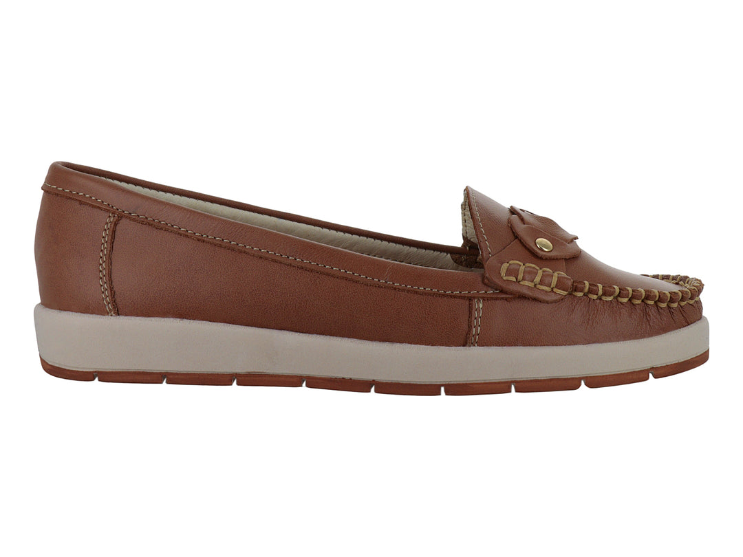 Zapato tipo mocasín color miel con suela beige y detalle decorativo de nudo con botón dorado.