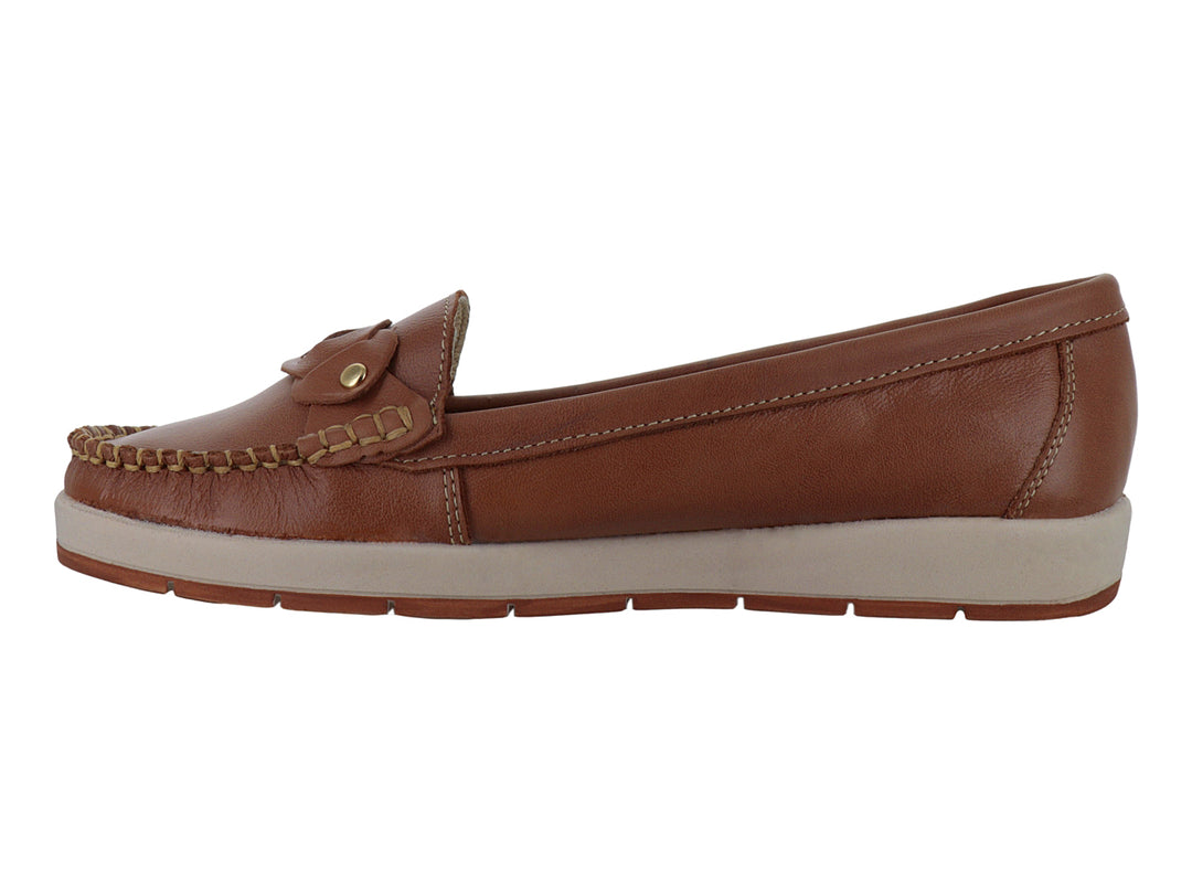Zapato tipo mocasín color miel con suela beige y detalle decorativo de nudo con botón dorado.