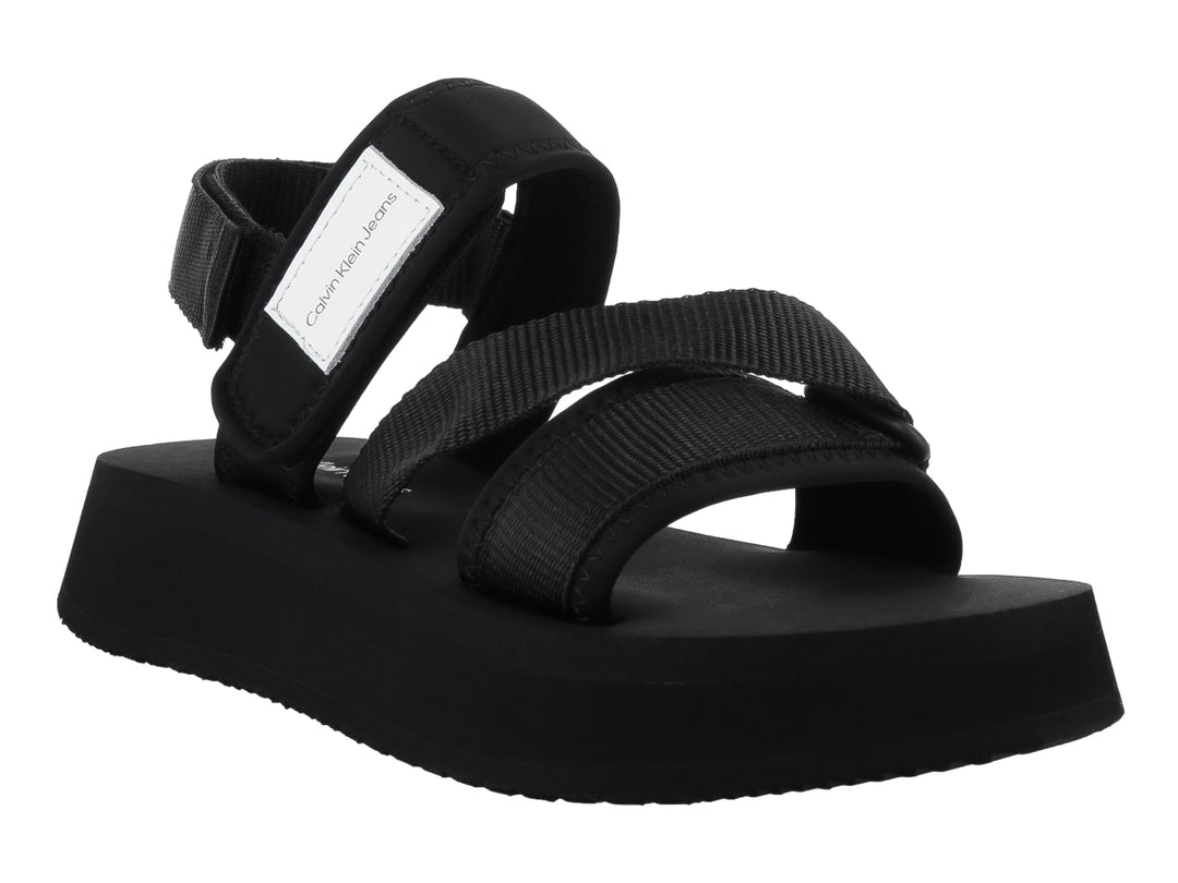 Sandalias negras de plataforma Calvin Klein con correas ajustables y suela gruesa sobre fondo blanco.