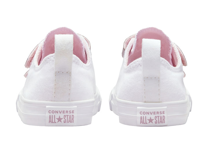Tenis Converse blancos con correas de velcro rosa con glitter.