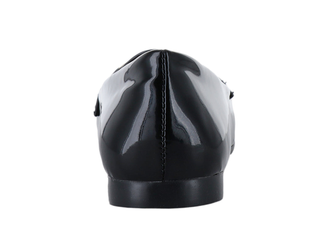 Zapato plano de charol negro con detalle de cadena dorada en la parte superior.