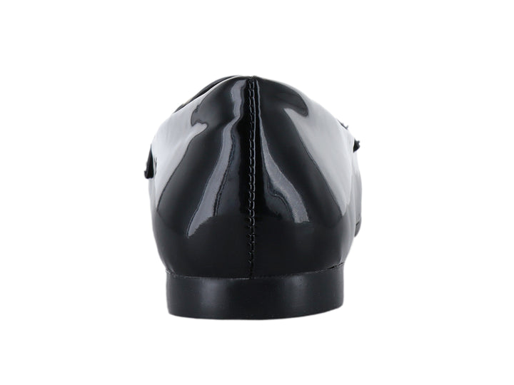 Zapato plano de charol negro con detalle de cadena dorada en la parte superior.