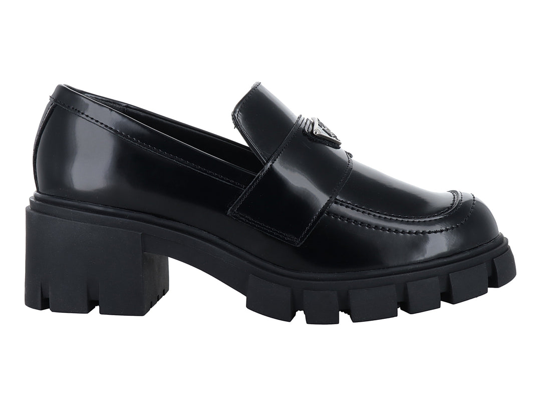 Mocasín negro brillante para mujer con suela de plataforma gruesa y detalle metálico.