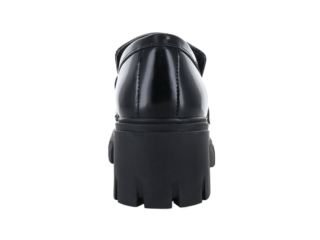 Mocasín negro brillante para mujer con suela de plataforma gruesa y detalle metálico.