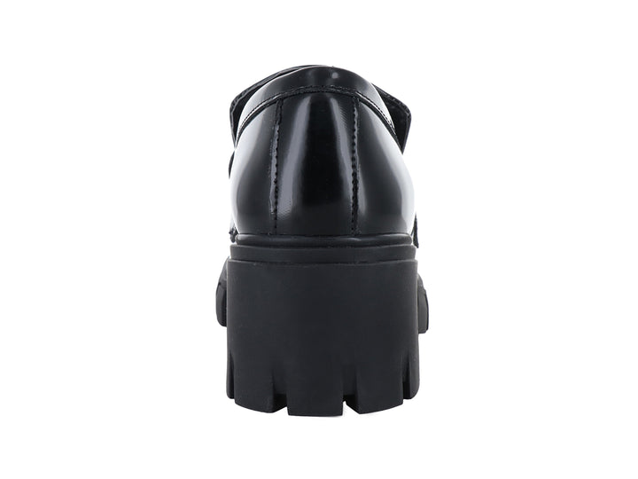 Mocasín negro brillante para mujer con suela de plataforma gruesa y detalle metálico.