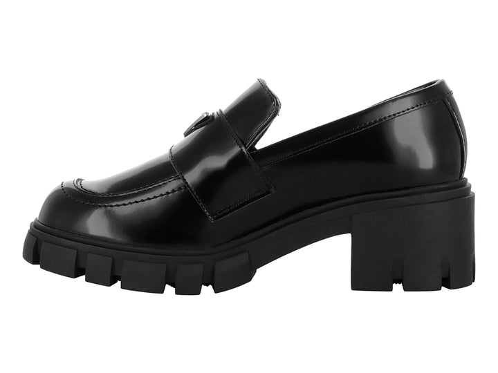 Mocasín negro brillante para mujer con suela de plataforma gruesa y detalle metálico.