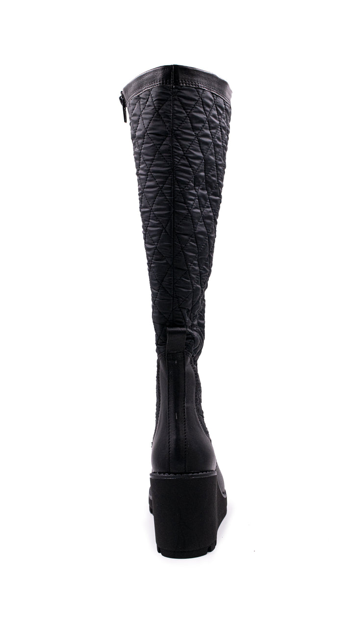 Bota alta color negro con diseño acolchado en la caña y suela de plataforma.