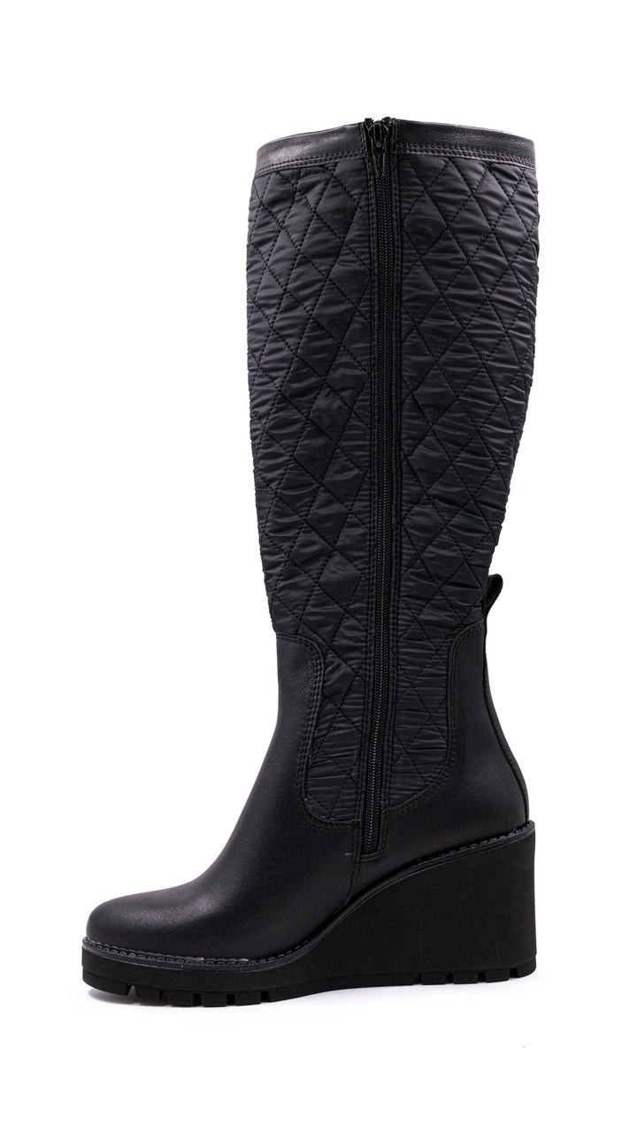 Bota alta color negro con diseño acolchado en la caña y suela de plataforma.