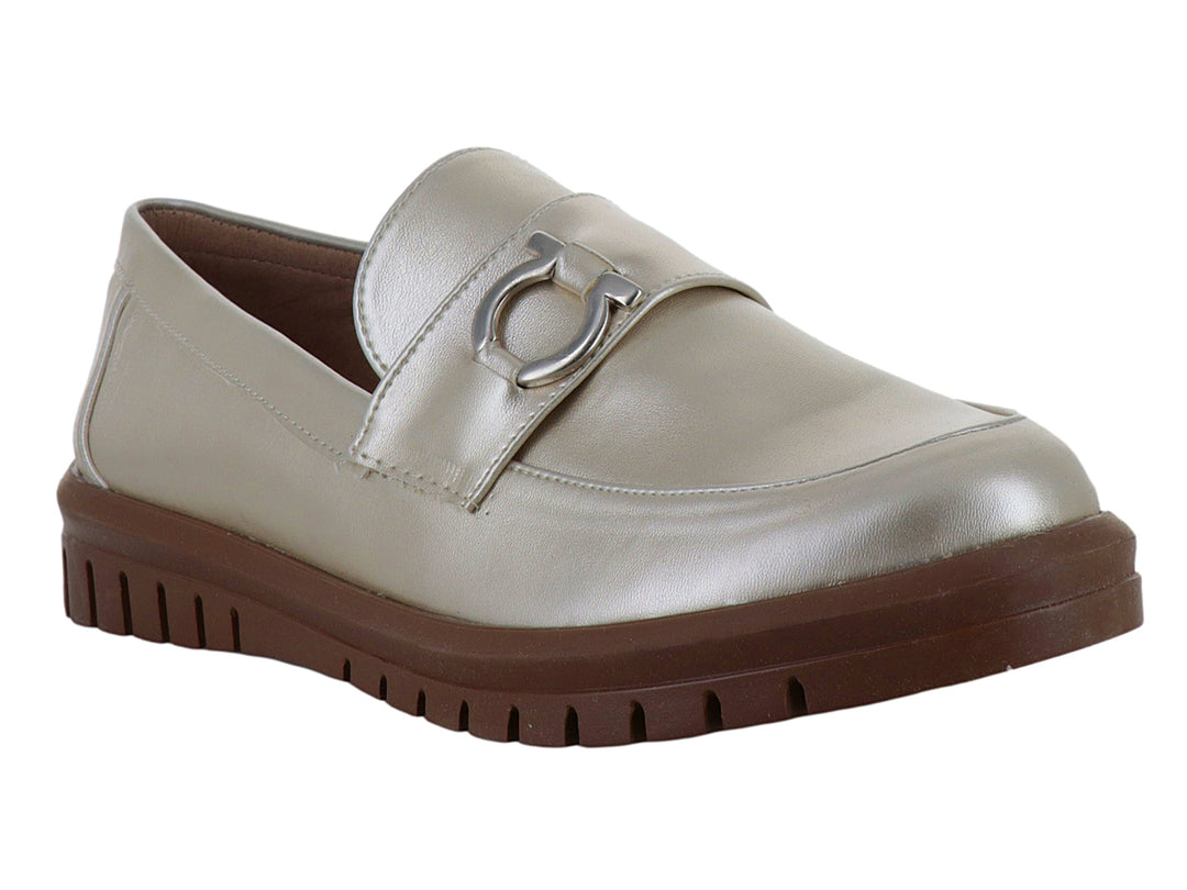 Zapato mocasín color plata metalizado con suela gruesa marrón y detalle decorativo frontal.