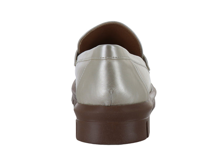 Zapato mocasín color plata metalizado con suela gruesa marrón y detalle decorativo frontal.