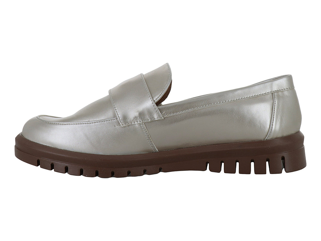 Zapato mocasín color plata metalizado con suela gruesa marrón y detalle decorativo frontal.