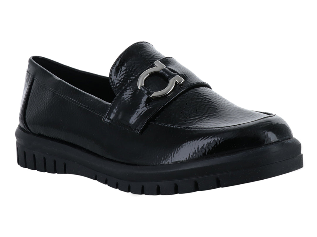 Zapato plano tipo mocasín Clinton en color negro de charol arrugado con hebilla plateada y suela gruesa.