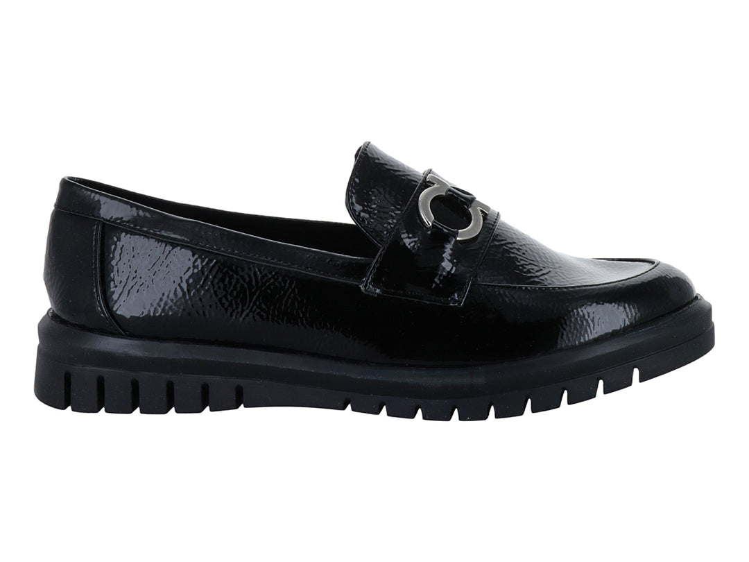 Zapato plano tipo mocasín Clinton en color negro de charol arrugado con hebilla plateada y suela gruesa.