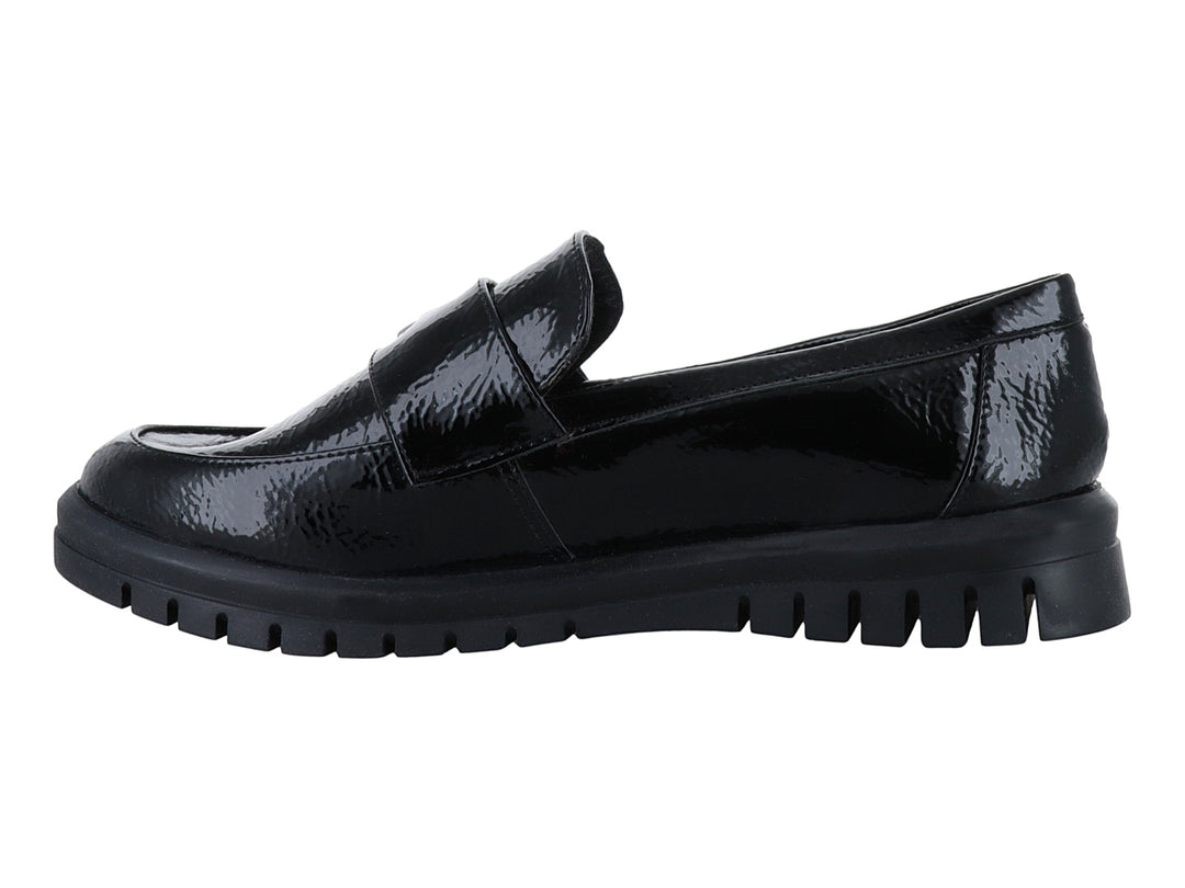 Zapato plano tipo mocasín Clinton en color negro de charol arrugado con hebilla plateada y suela gruesa.
