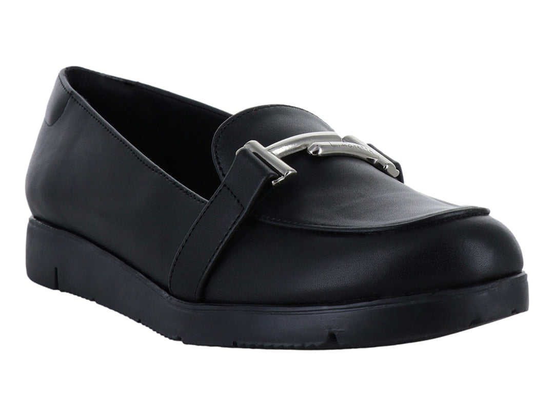 Zapato plano tipo mocasín color negro con detalle de hebilla plateada y suela ancha.