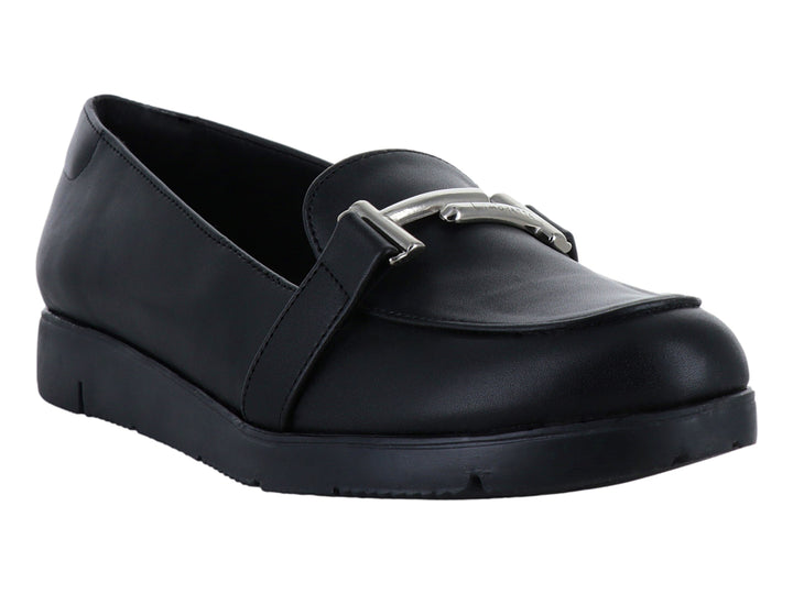 Zapato plano tipo mocasín color negro con detalle de hebilla plateada y suela ancha.