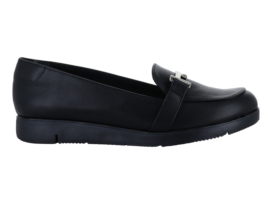 Zapato plano tipo mocasín color negro con detalle de hebilla plateada y suela ancha.