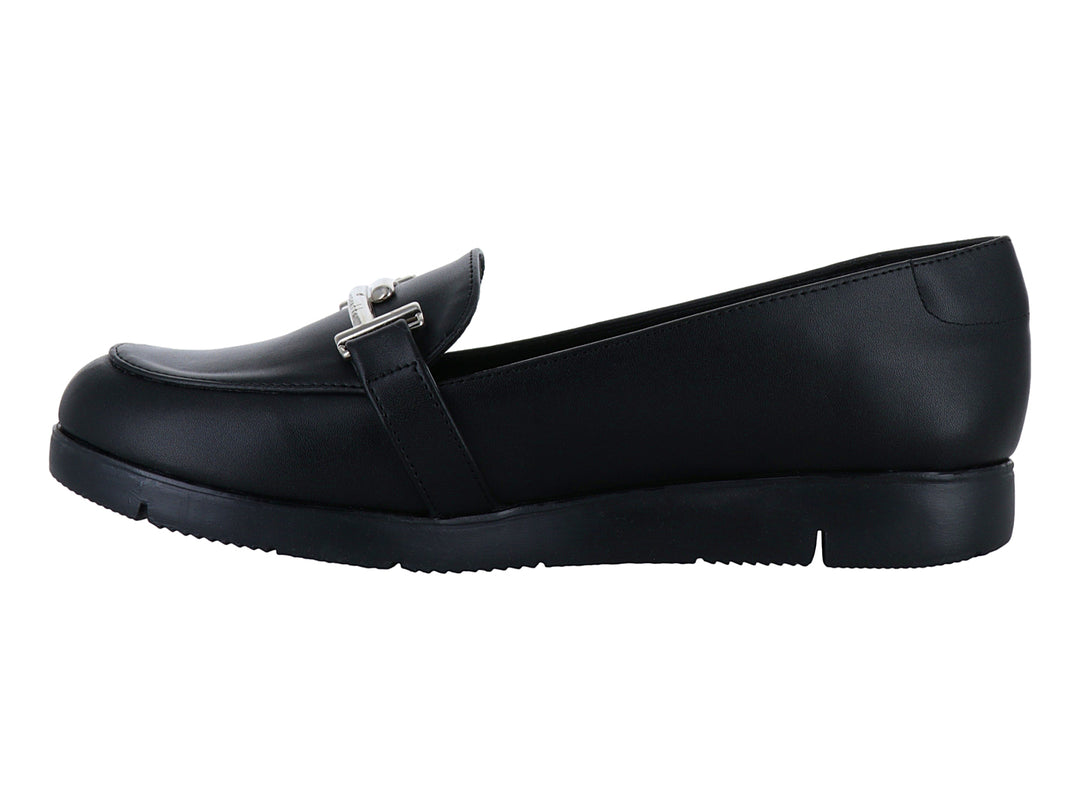 Zapato plano tipo mocasín color negro con detalle de hebilla plateada y suela ancha.
