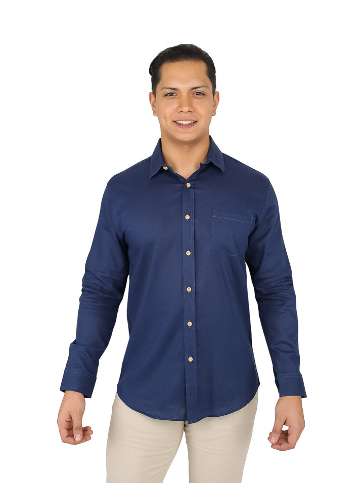 Hombre vistiendo camisa casual de manga larga en color azul marino con botones y bolsillo frontal.